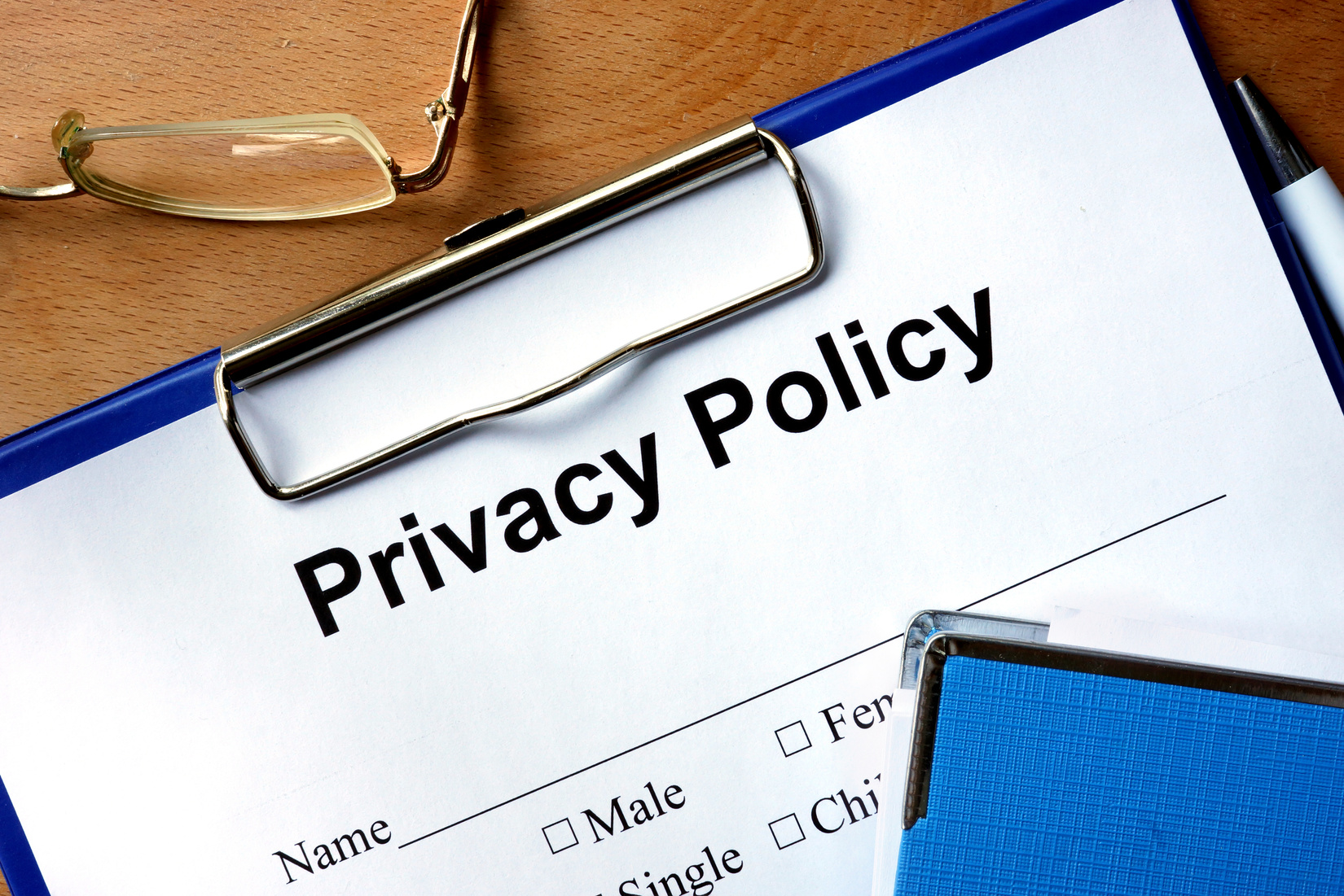 Privacy policy form on a wooden table and pen.